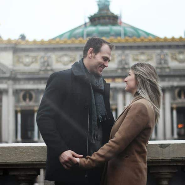 The couple is holding hands while looking at each other.