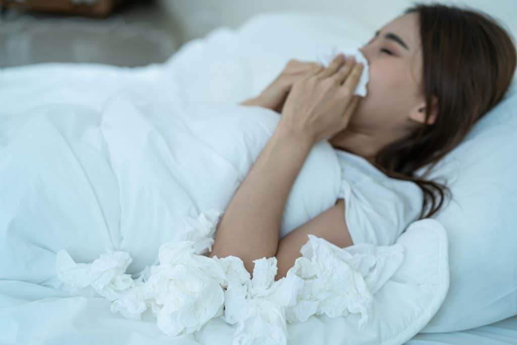 The woman with colds is sleeping in her bedroom.