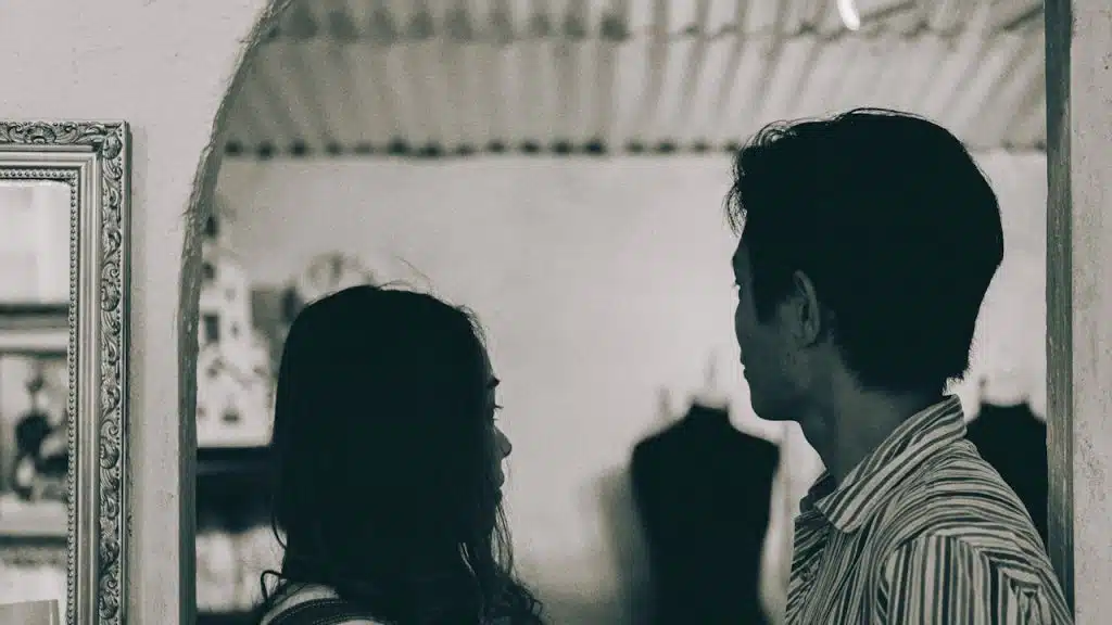 A man and a woman standing in grayscale photography.