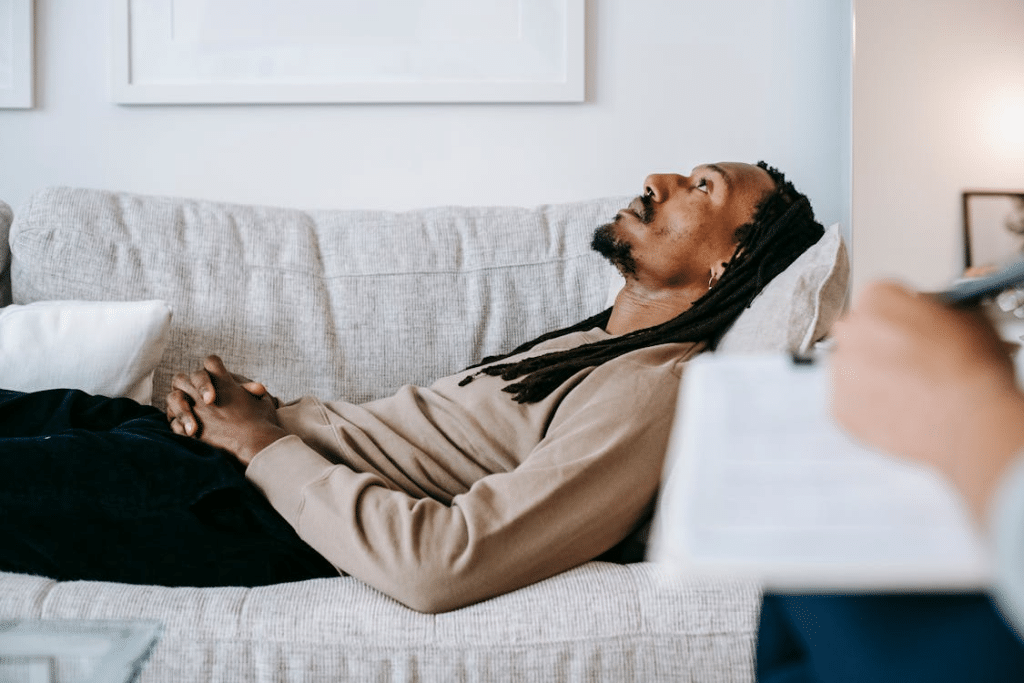 Black man resting and lying on cozy sofa