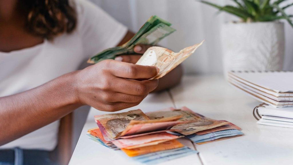 A woman counting money after monthly savings.