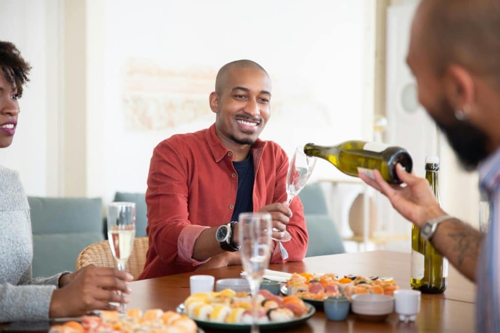 The man in a red shirt is holding a wine glass.