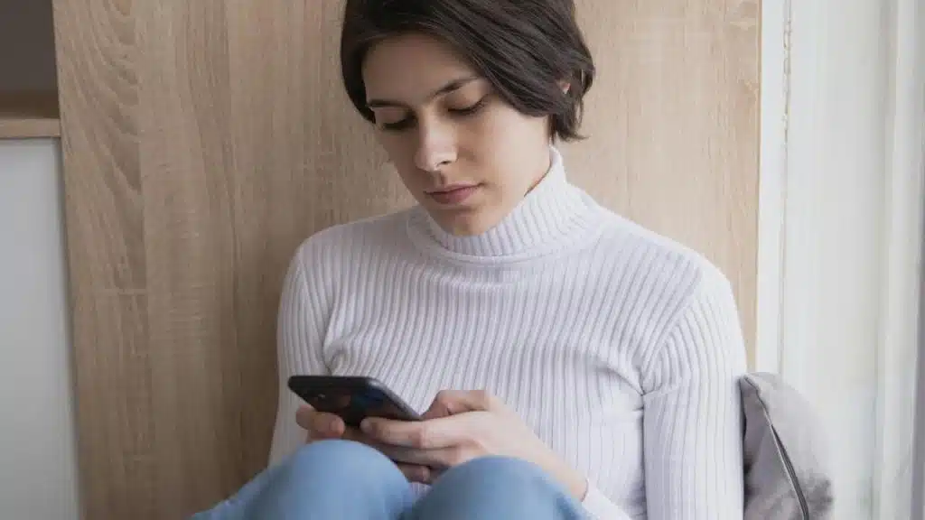 A woman looks down at her phone.