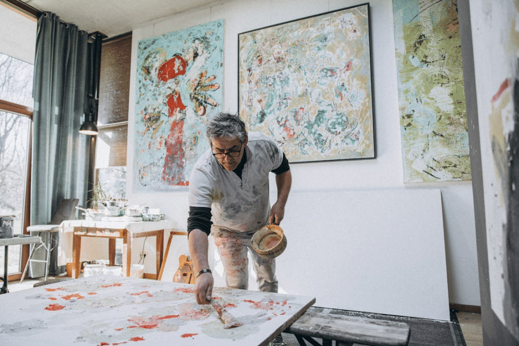 Man Painting a Picture on a Canvas in a Studio