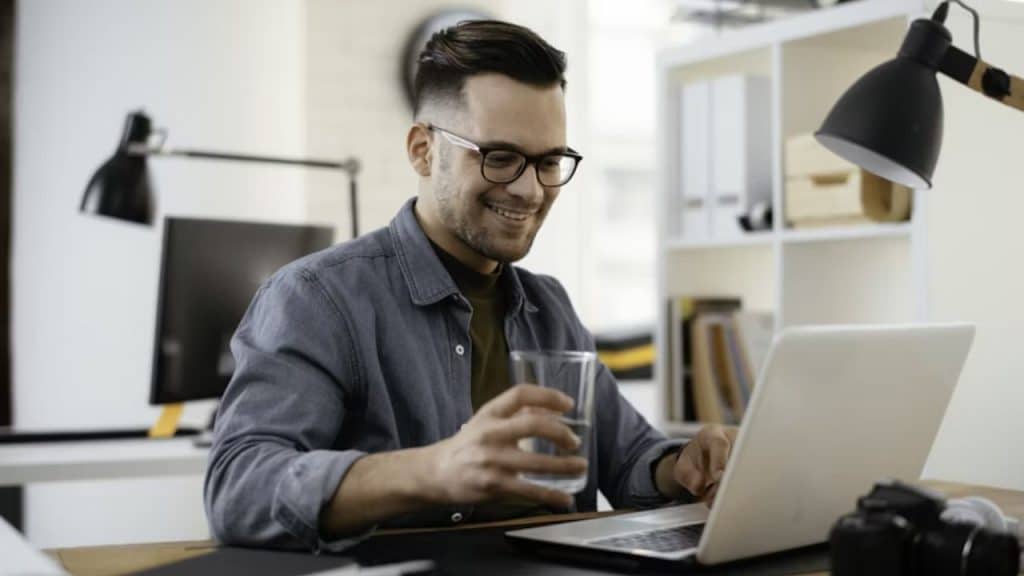 Man reading an article online in a cozy study environment