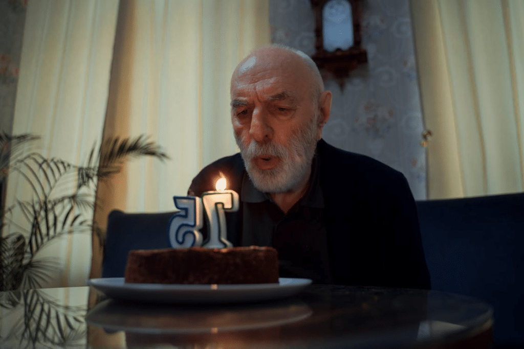 Elderly Man Blowing at his Birthday Cake