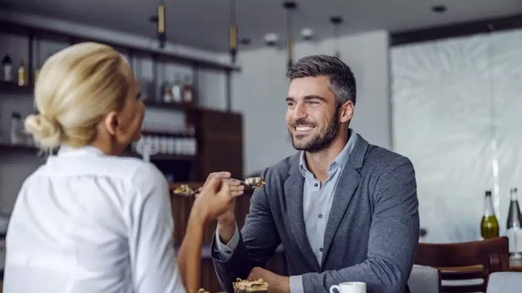 Man sitting at a café smiling during a casual conversation