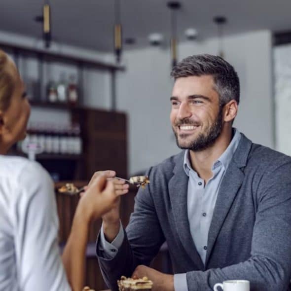Man sitting at a café smiling during a casual conversation