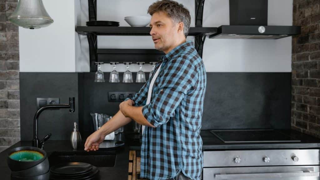 Man doing household chores while looking frustrated