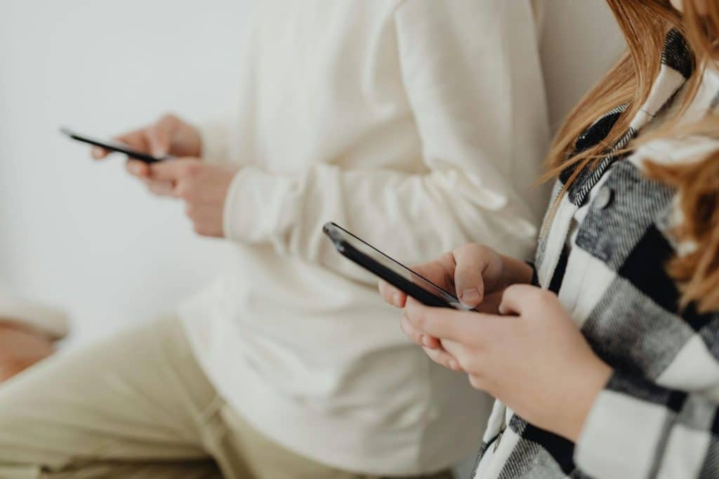 A man and woman using phones