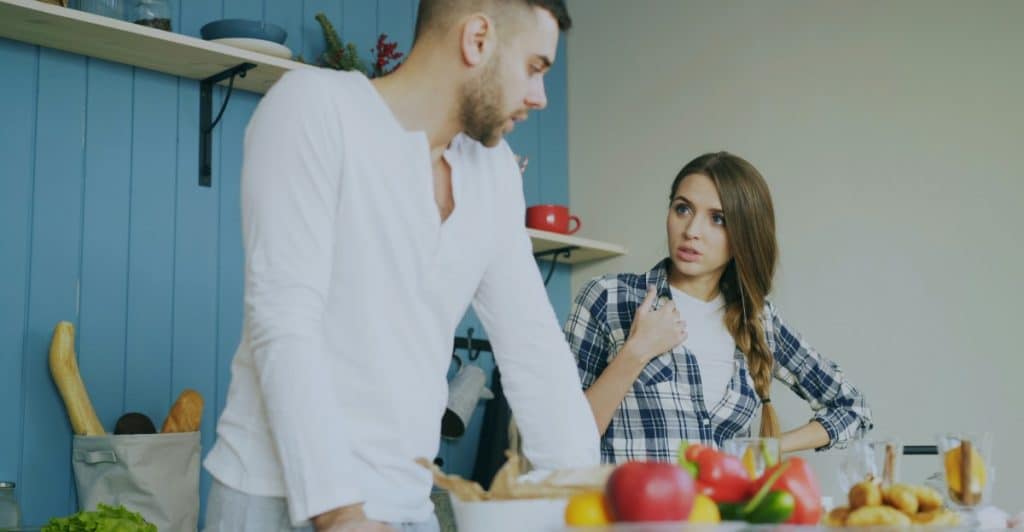 A couple arguing in the kitchen.