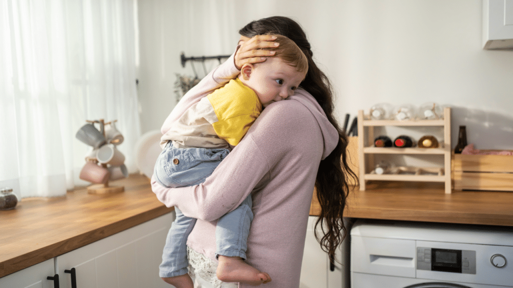 A woman carrying her baby at home