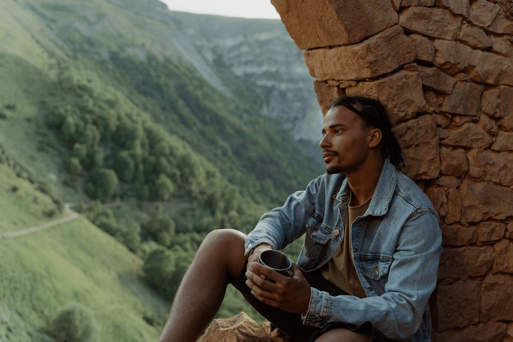A Man Sitting While Holding a Steel Glass