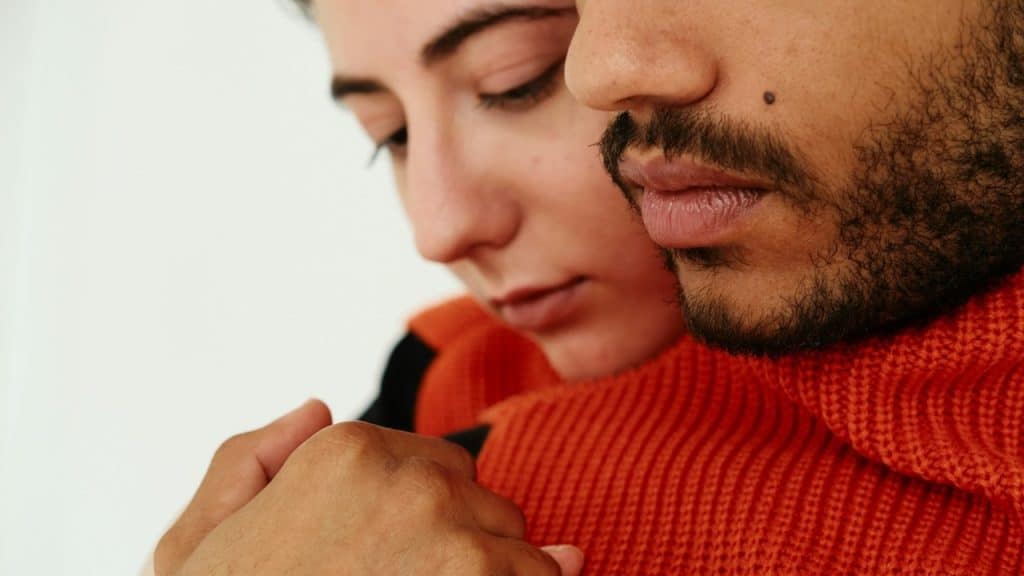 A man holding a woman from behind.