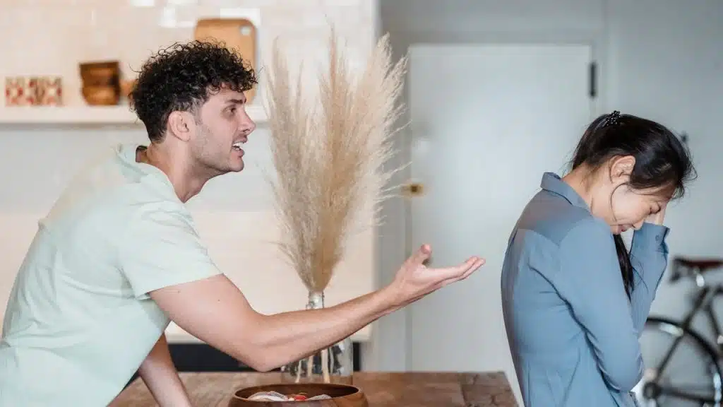 A couple arguing in a kitchen.