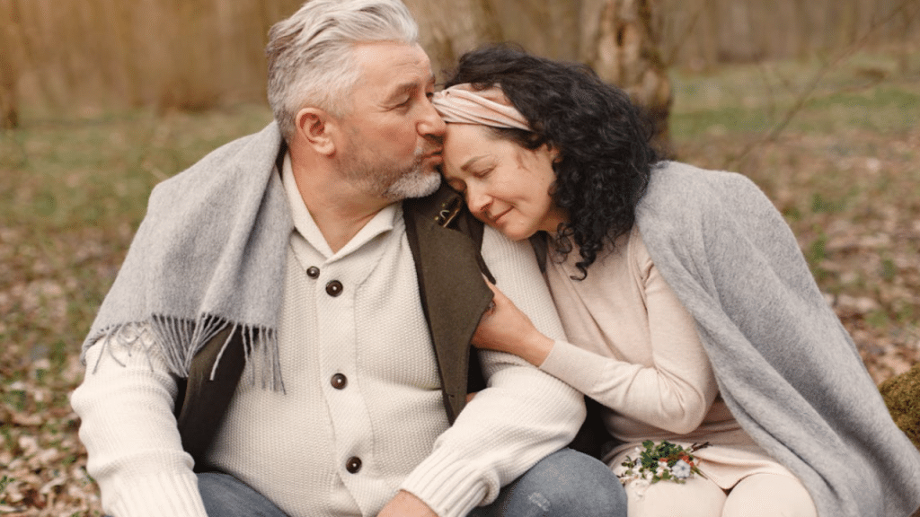 A man giving his wife a forehead kiss