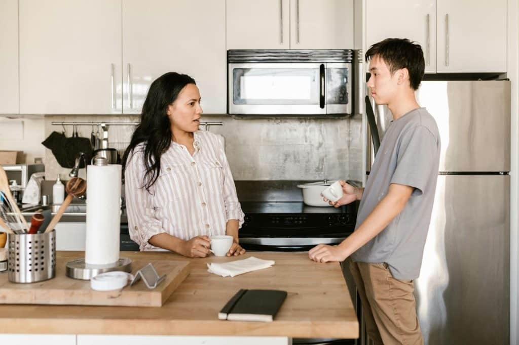 A man and woman at the kitchen having discussion