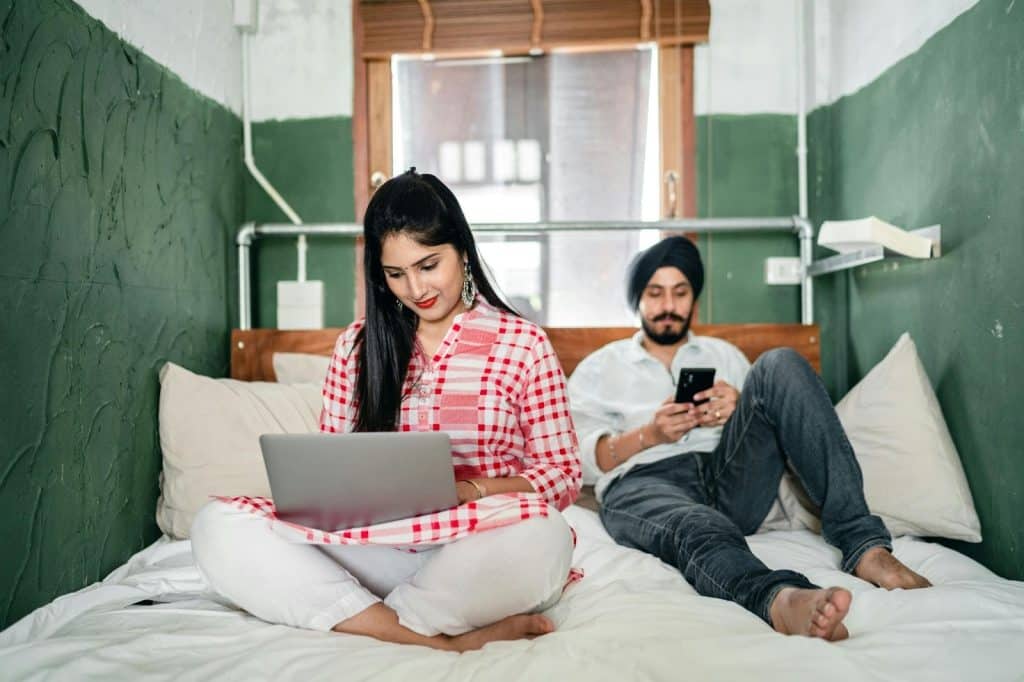A man and woman using their gadgets