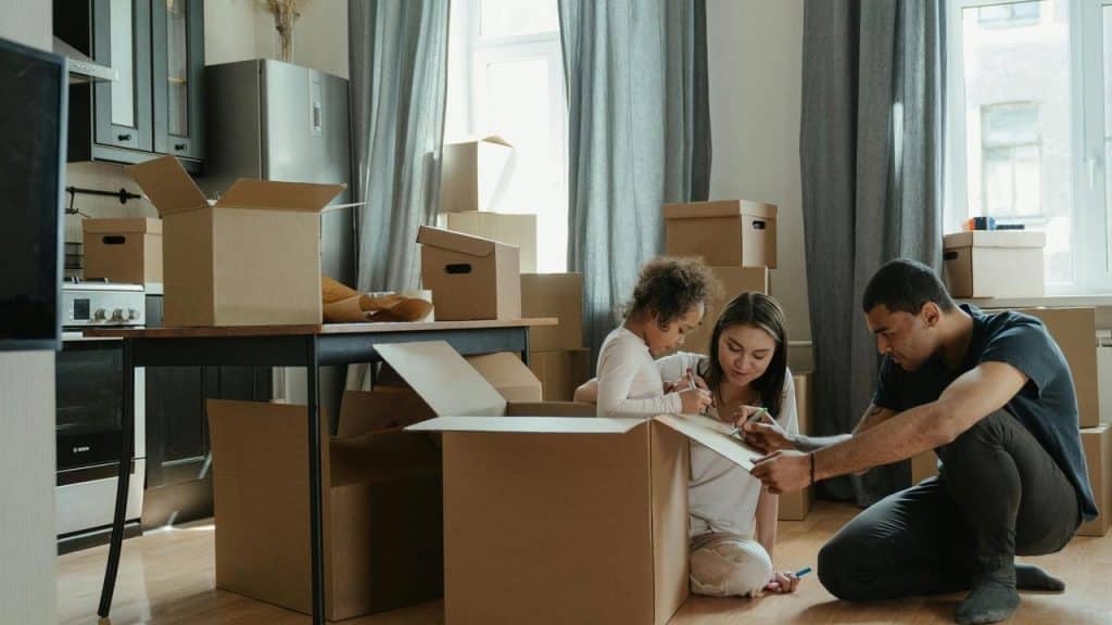 A family packing cardboard boxes together in their home.