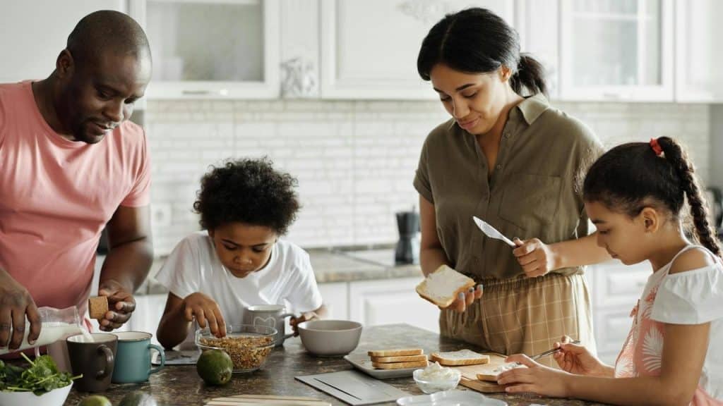 A family preparing breakfast together in a kitchen.
