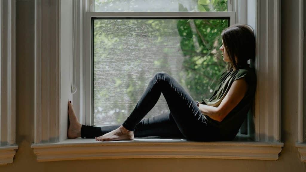 A woman sitting on a windowsill.