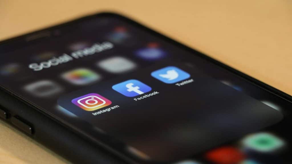 A close-up of a smartphone screen showing a folder labeled "Social media" with the app icons for Instagram, Facebook, and Twitter.