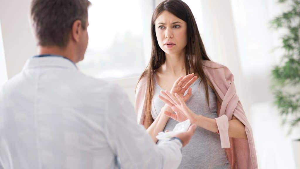 A woman refusing to take medicine for mental health.