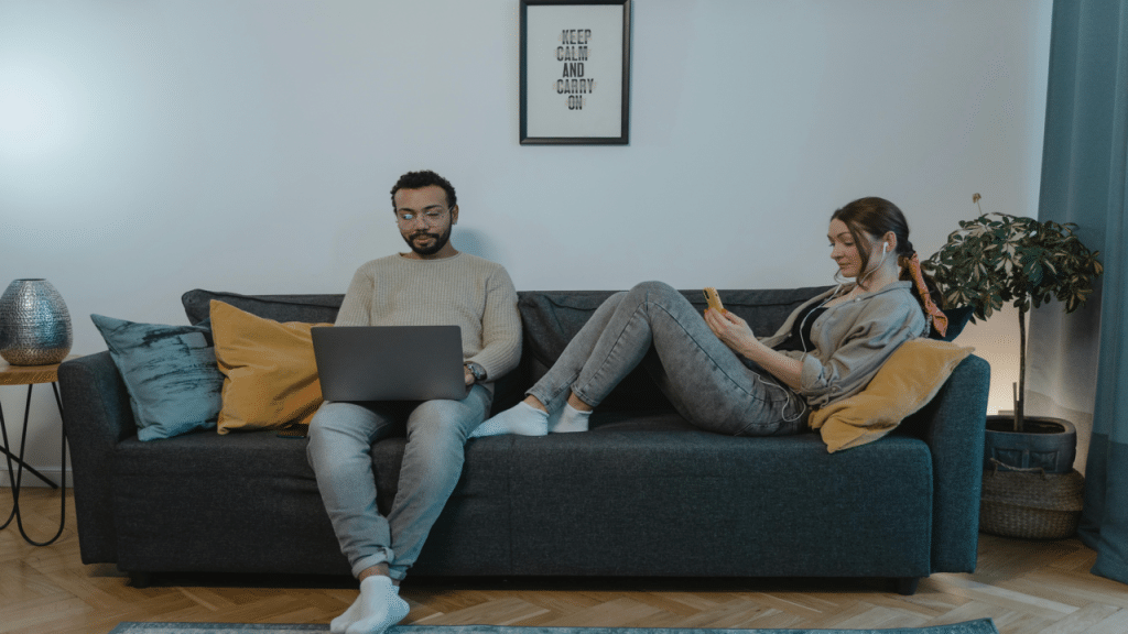 A couple ignoring each other while in the living room