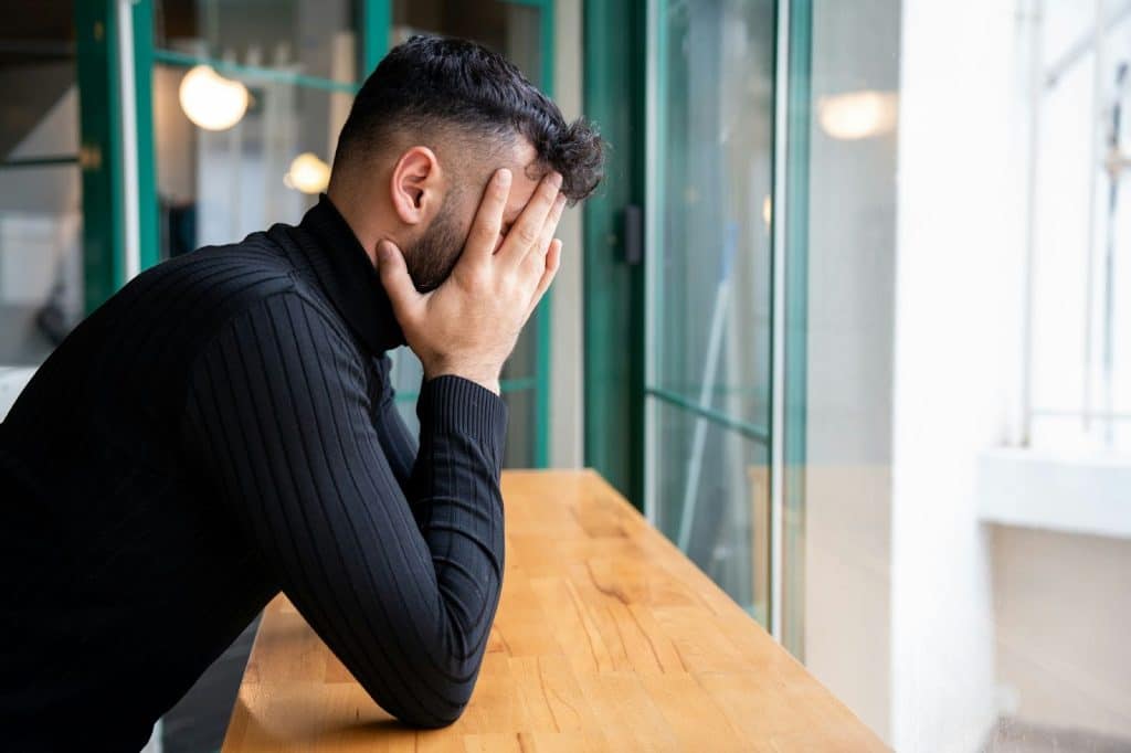 A man covering his face