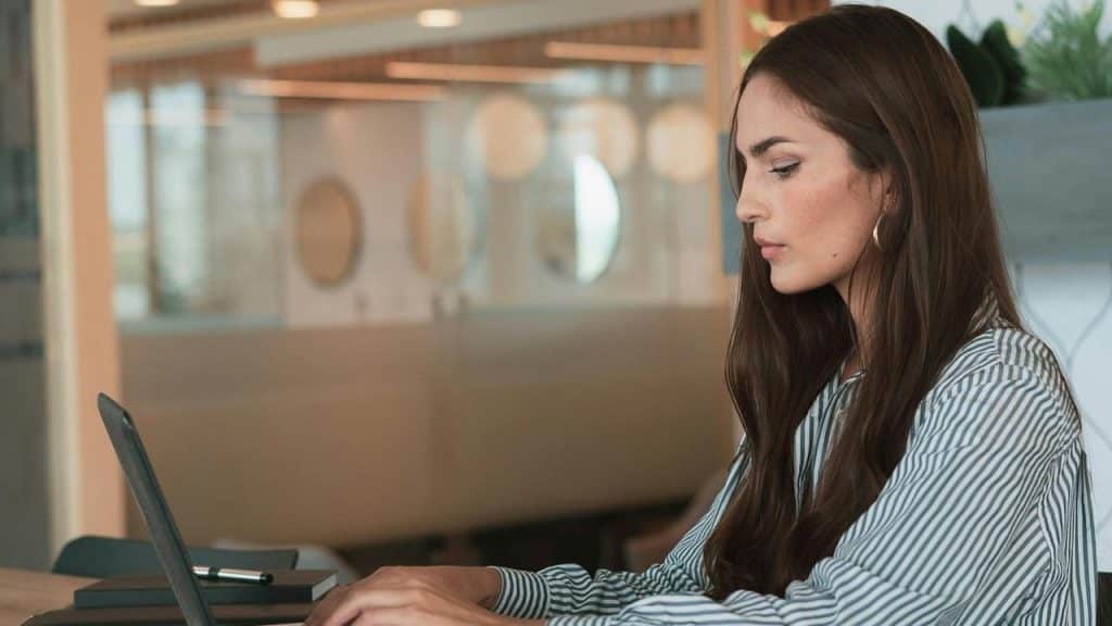 A woman working on a laptop in a modern office.