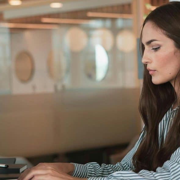 A woman working on a laptop in a modern office.