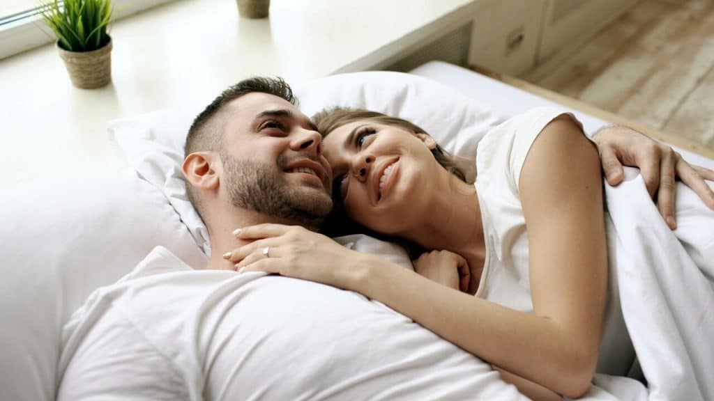 A couple snuggling in bed