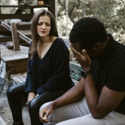 The woman is looking at the crying man.