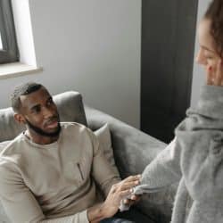 The man is holding the woman’s hand.