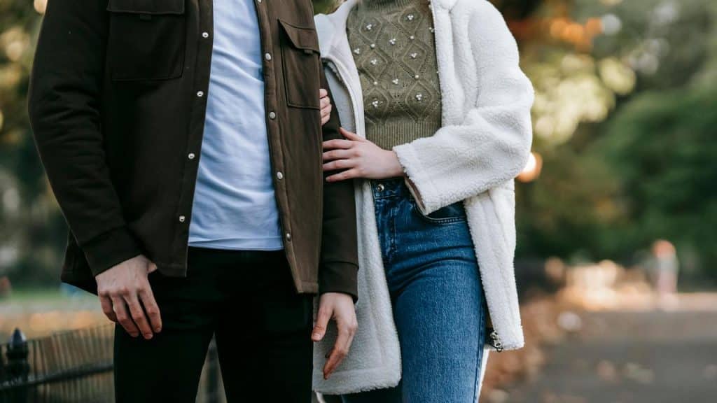 A couple walking arm in arm outdoors.