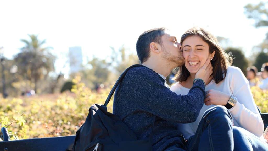 A couple sharing a warm smile while sitting outside.