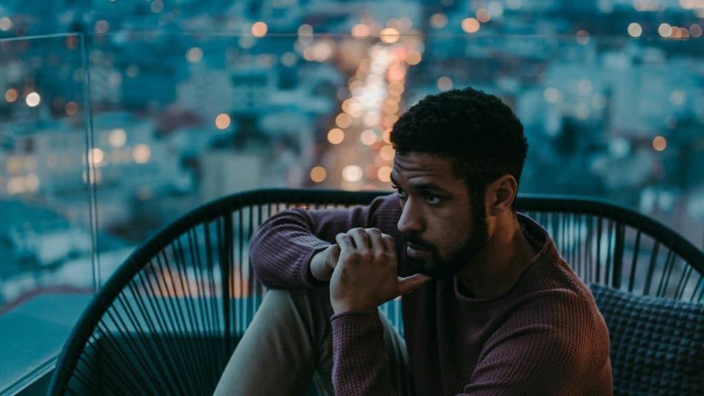 A man sitting alone deep in thought at night.