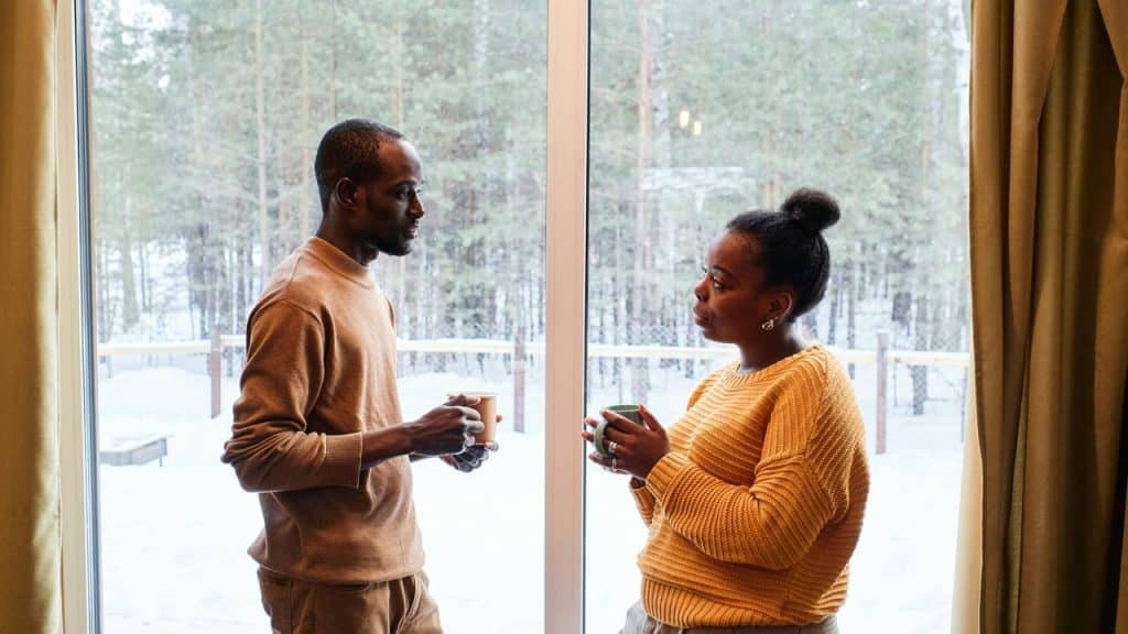 A couple drinking coffee and having a serious conversation.