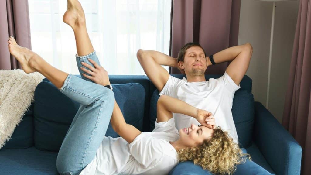 A happy couple relaxing together on the couch.