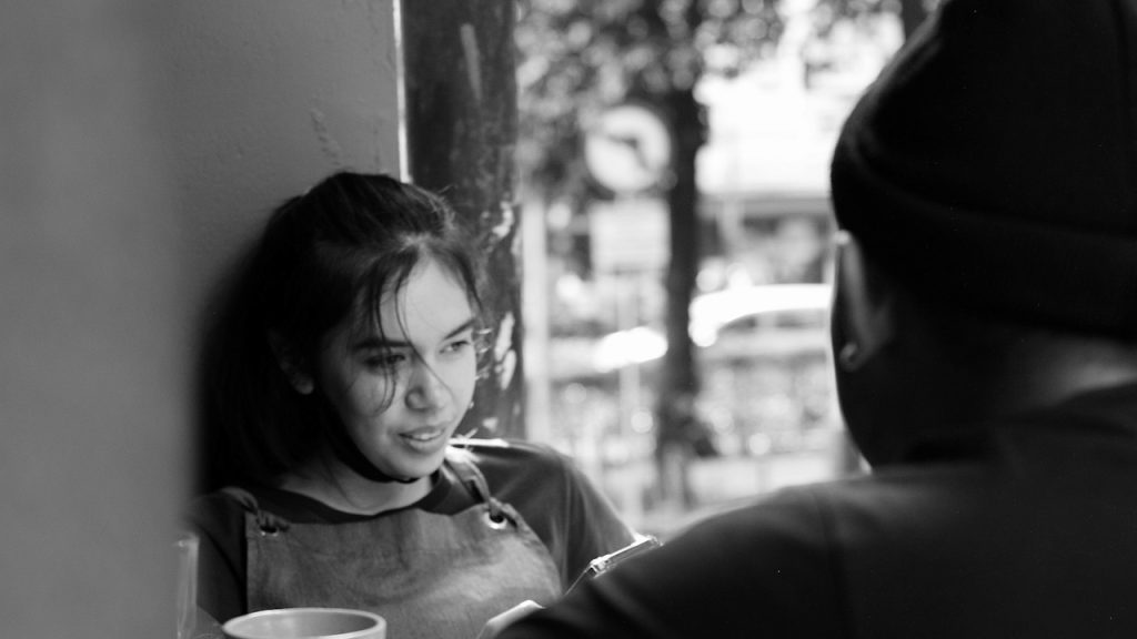 A man and a woman sitting outdoors.