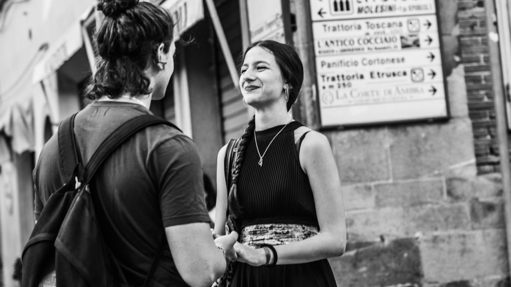 A woman in a sleeveless dress standing beside a man in a black jacket.