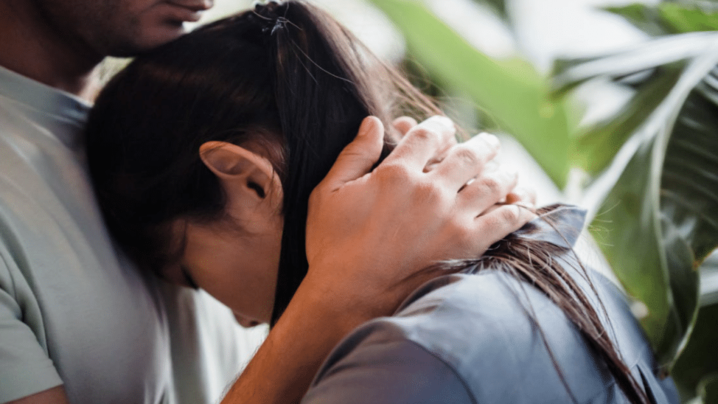 A couple hugging beside a plant