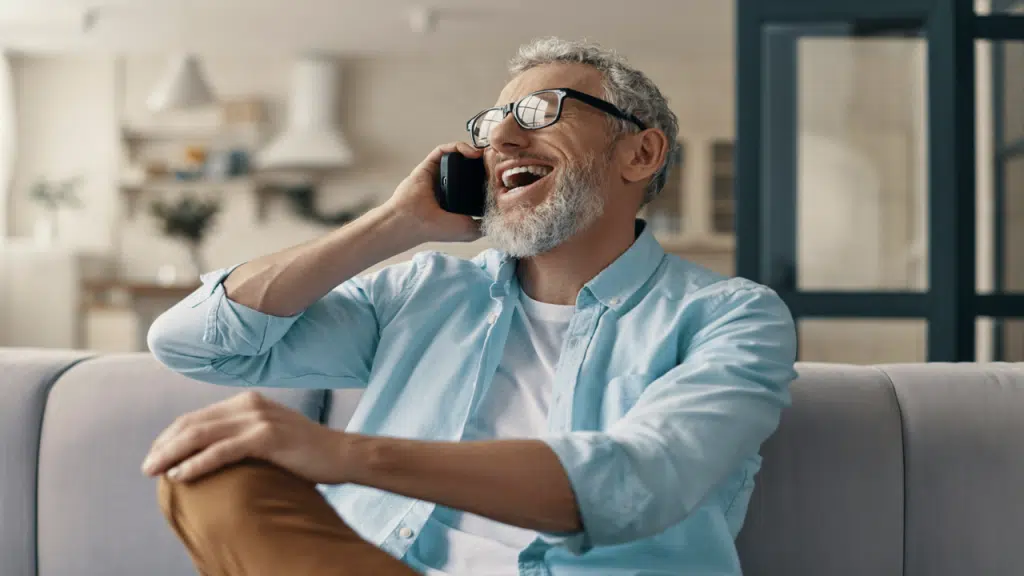 A man laughing while talking on the phone