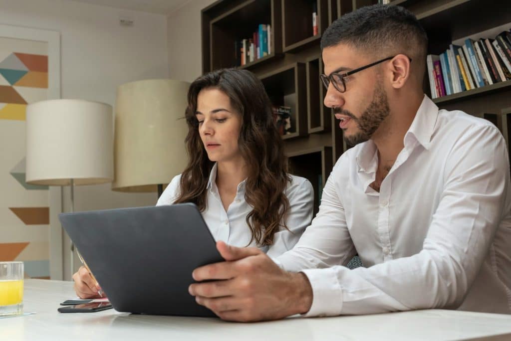A man and woman busy and looking at the laptop