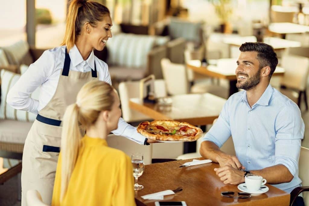 A woman observing a man talking to a waitress