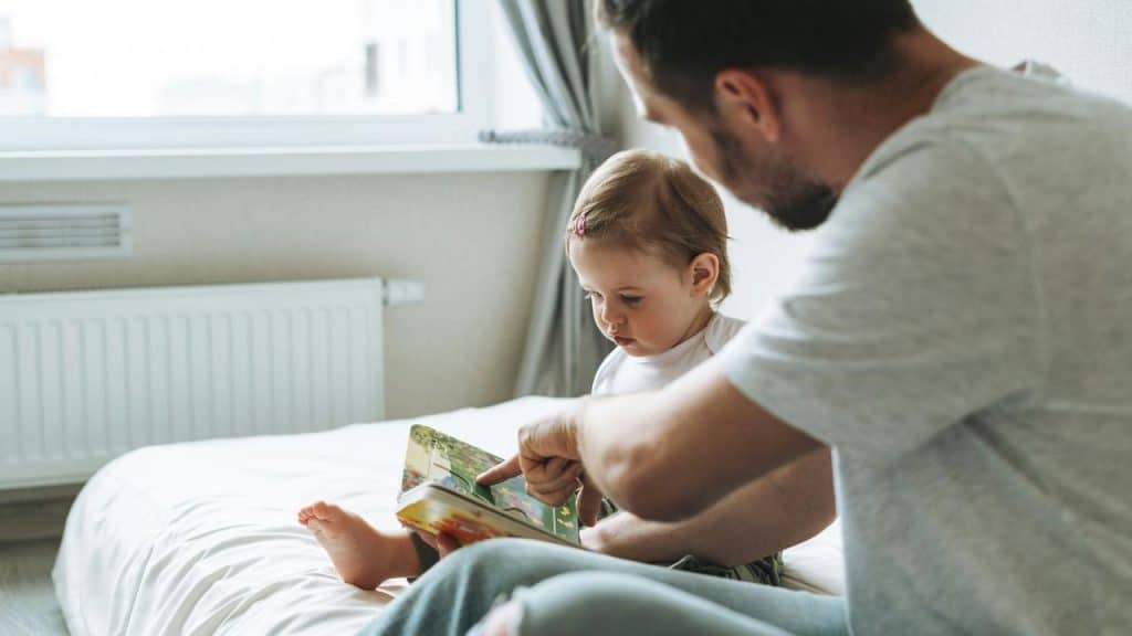 A father reads a bedtime story to his child.