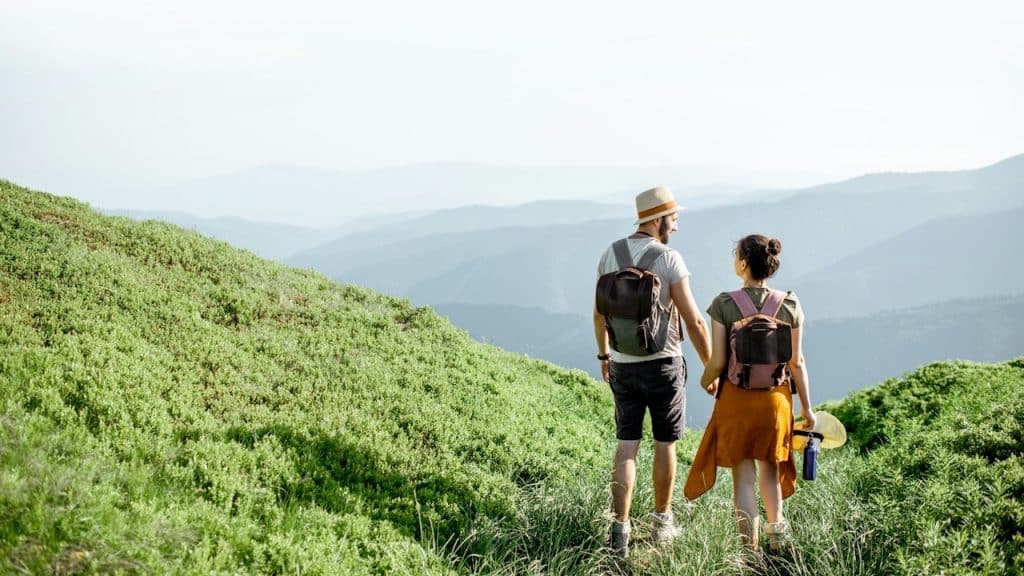 A couple holding hands while hiking together.