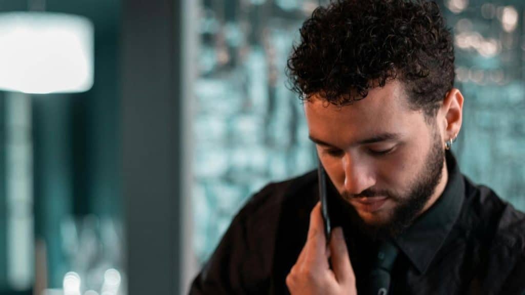 A man talking on a mobile phone while looking down thoughtfully.