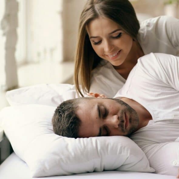 A woman trying to wake her husband