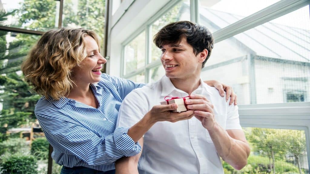 A woman giving a man a gift